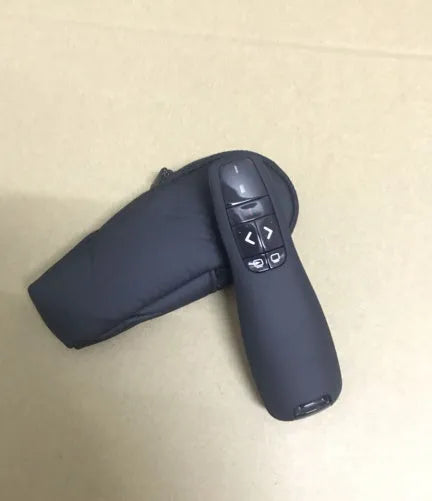 Black wireless presenter pen with laser pointer and slide control buttons next to its small USB receiver.