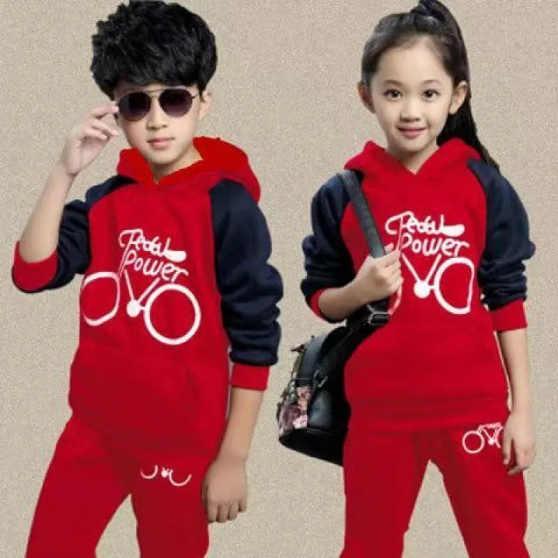 Older child wearing a black two-piece sports suit with long sleeves and print detail.