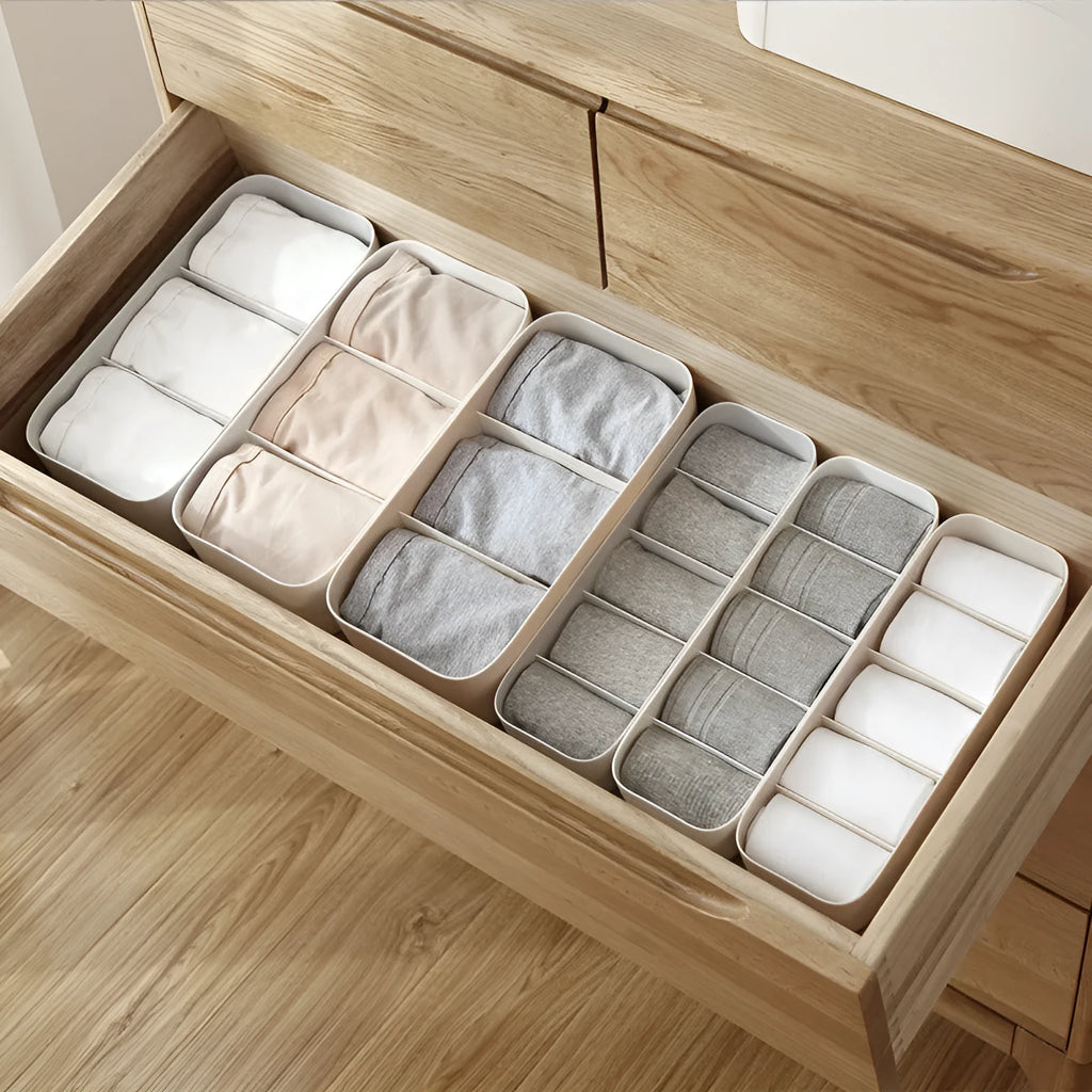 PP plastic socks and underwear storage box with grid compartments in apricot colour on a desktop