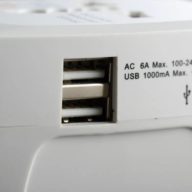 White universal travel plug adapter with dual USB ports and interchangeable UK EU US AU plugs on a plain background