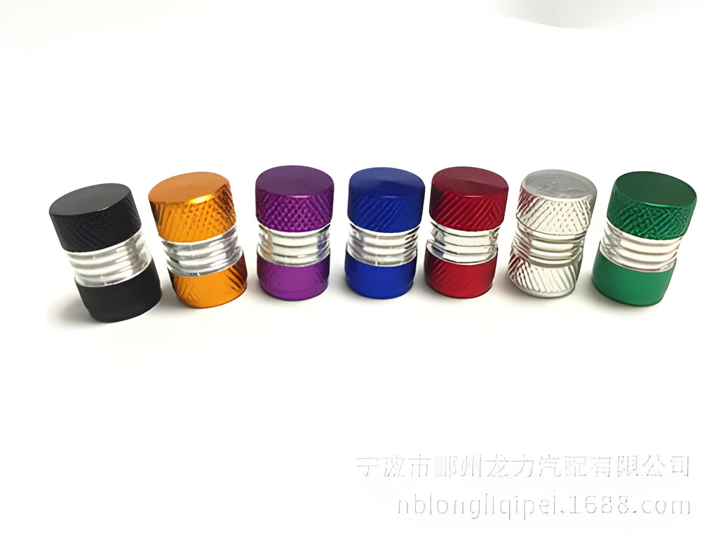 Seven aluminium alloy tyre valve dust caps in black, blue, gold, green, purple, red, and silver on a white background.
