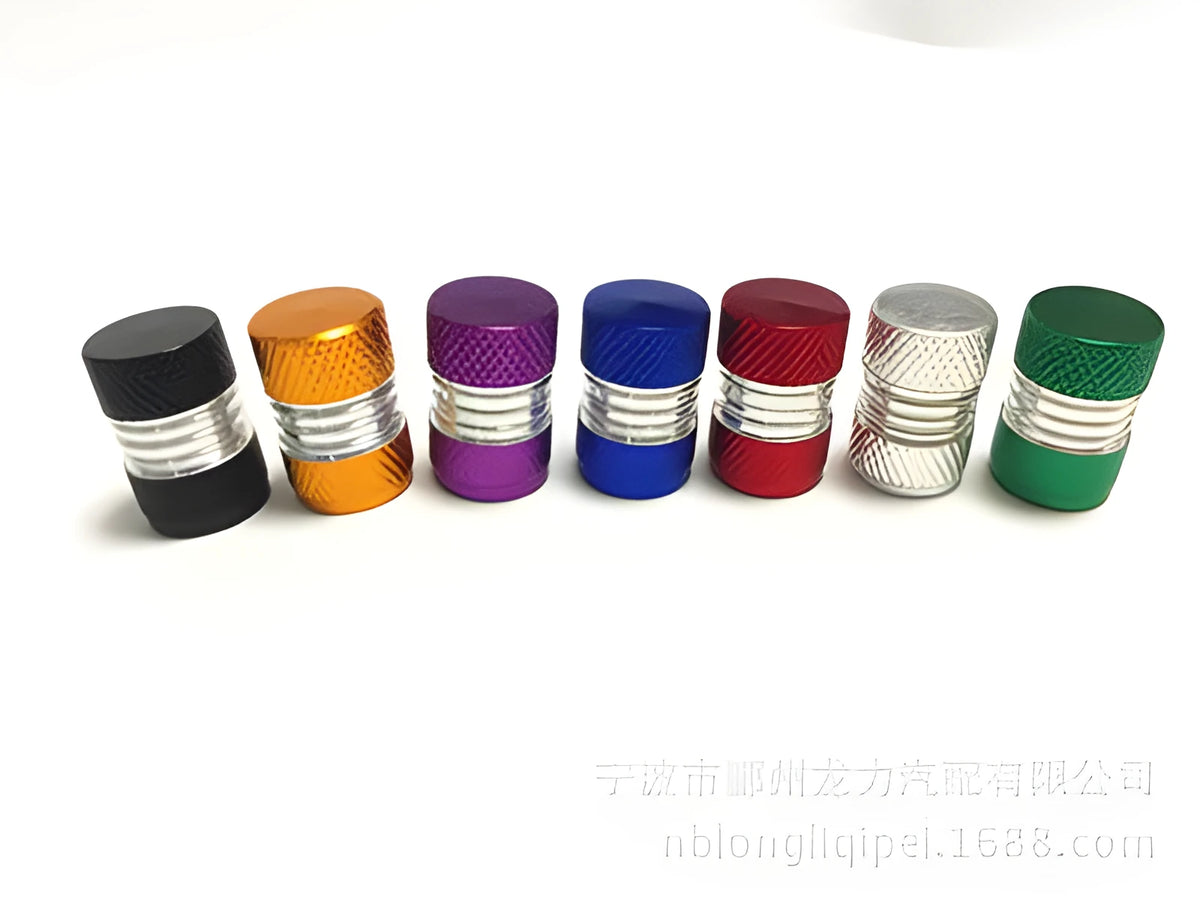 Seven aluminium alloy tyre valve dust caps in black, blue, gold, green, purple, red, and silver on a white background.