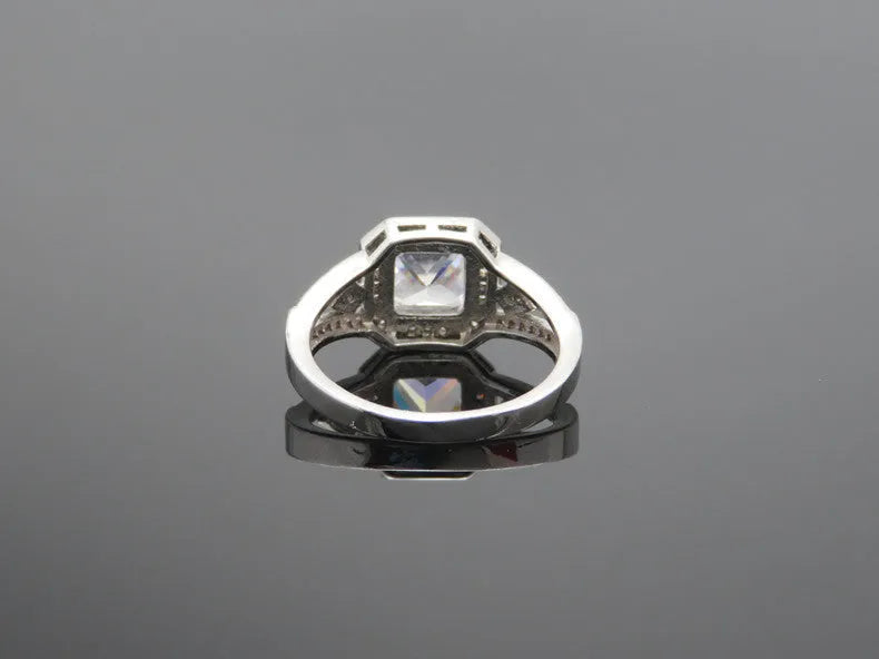 Geometric hollow design women's zircon ring in platinum finish on copper, showing quadrilateral stone.