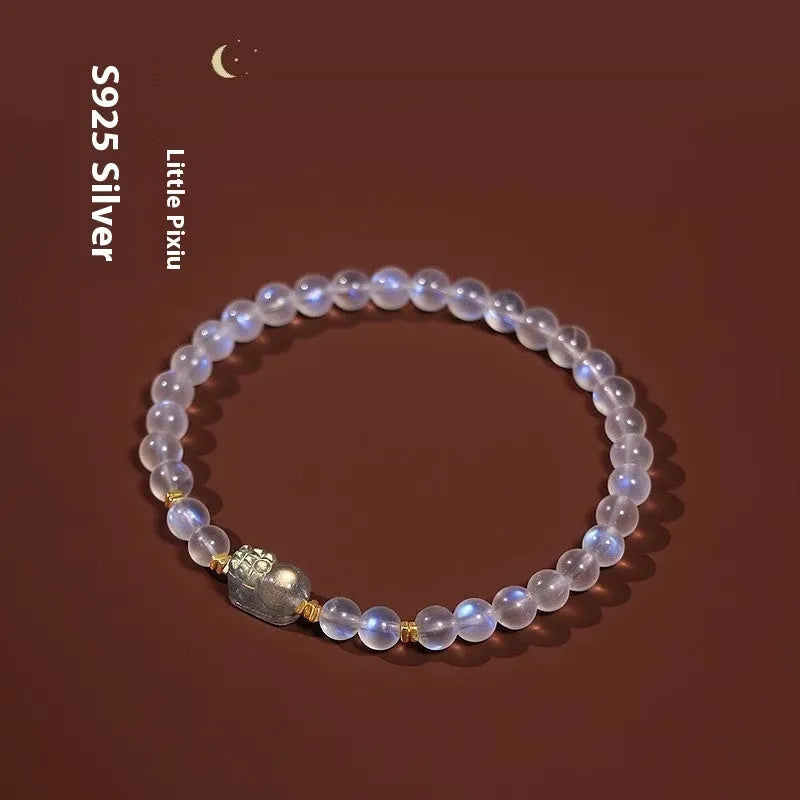 Close-up of a moonstone bracelet with a carved animal or zodiac design, showing grinding finish and blue light trend detail.