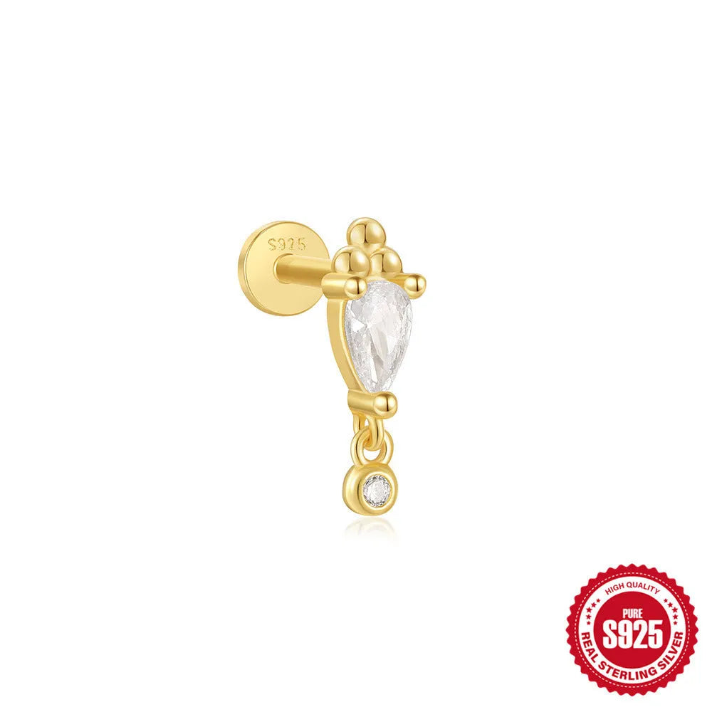 Close-up of a gold-coloured S925 sterling silver ear stud with a XINGX pattern inlay and a thin dangling tassel.