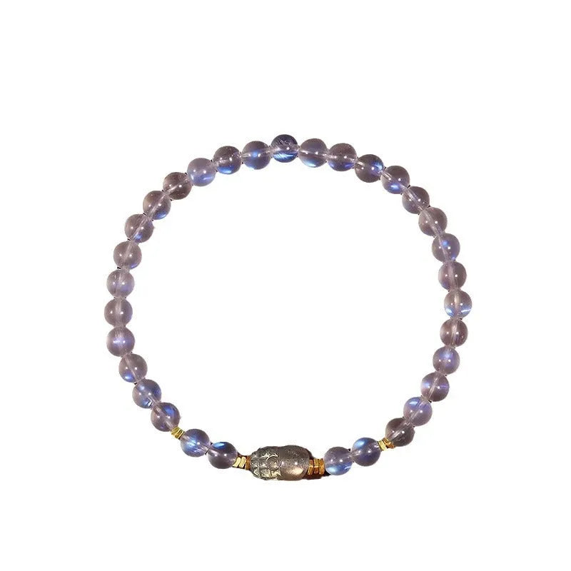 Close-up of a moonstone bracelet with a carved animal or zodiac design, showing grinding finish and blue light trend detail.