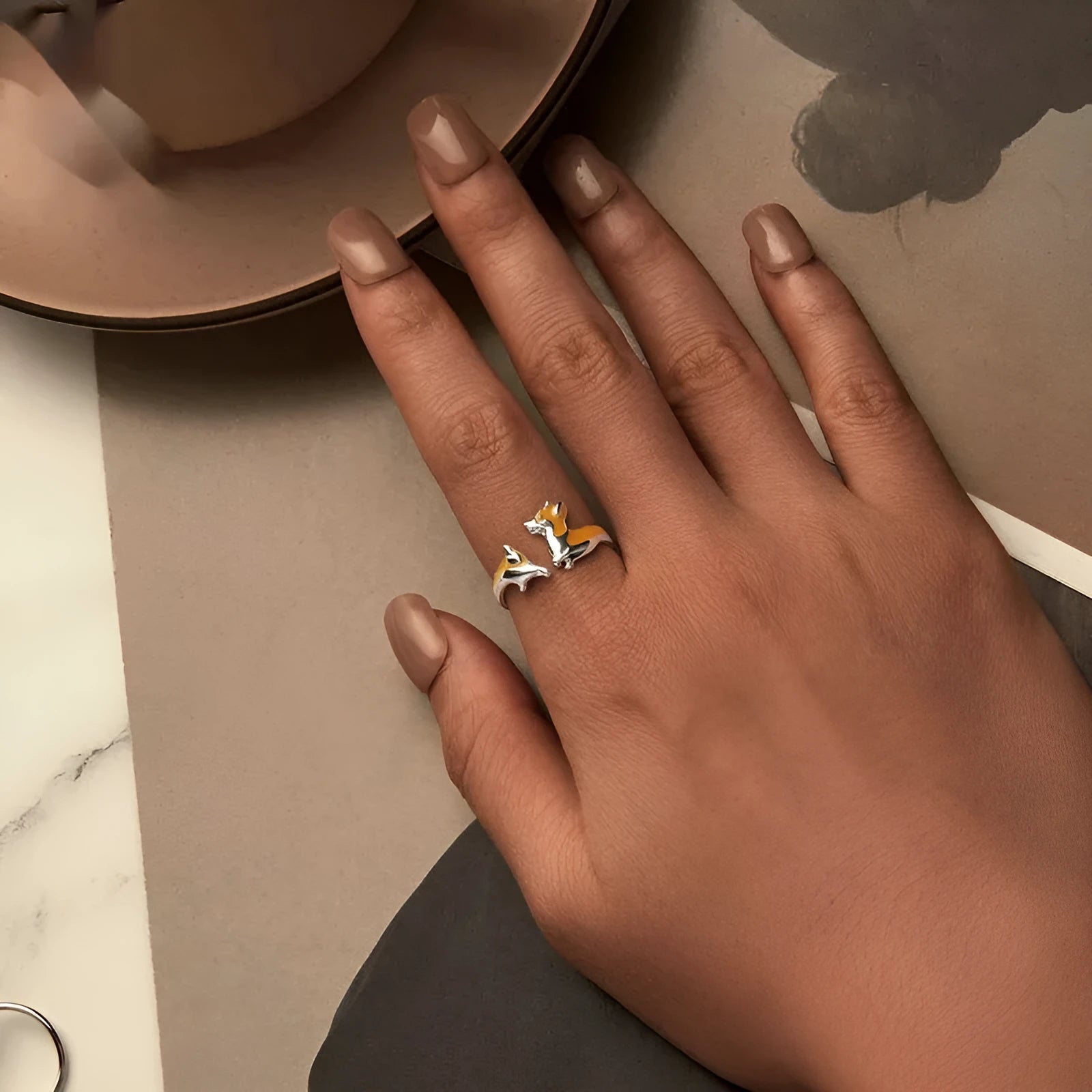 Silver ring with a raised cartoon corgi dog design on the band.