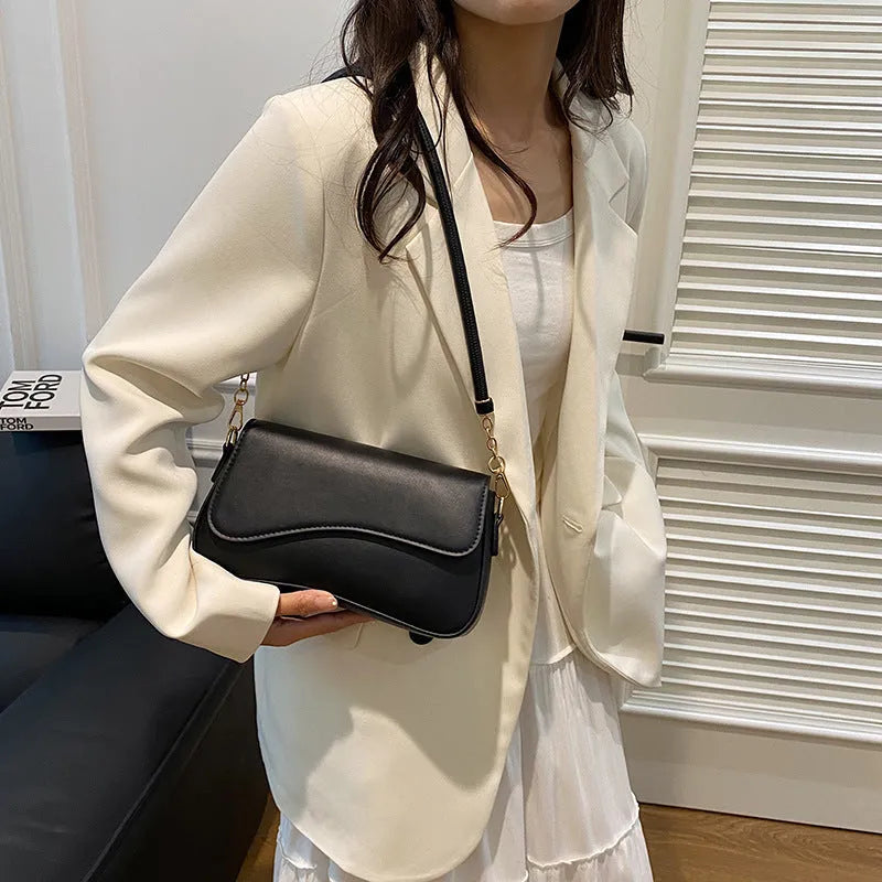 Retro women's messenger bag in black PU leather with horizontal square shape and double shoulder straps.