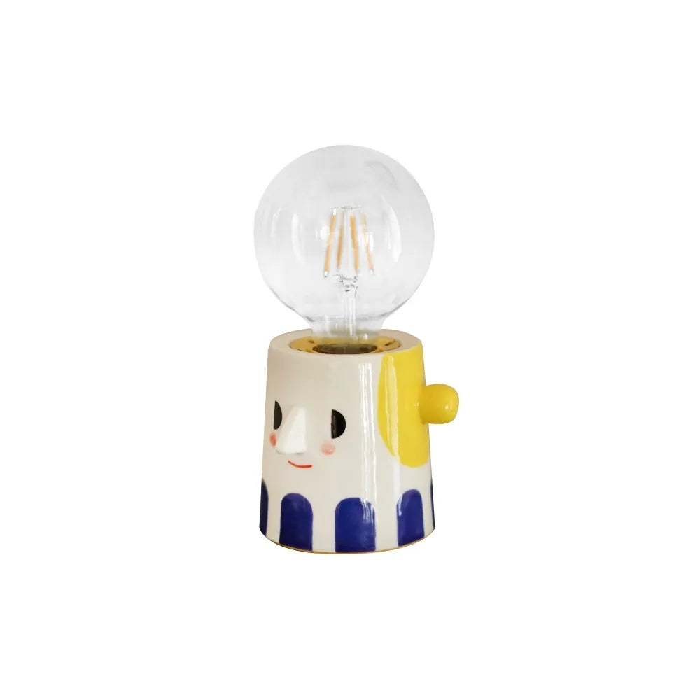 Handmade white ceramic table lamp with a creative ball headlight design on a wooden surface.