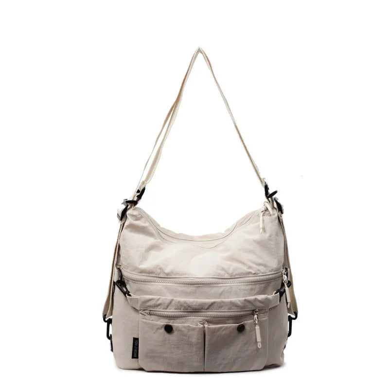 A square-shaped nylon crossbody bag for women in a choice of colours, showing shoulder straps and external pocket.