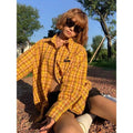 Dopamine yellow and black plaid shirt on a hanger, showing loose fit and cardigan style.