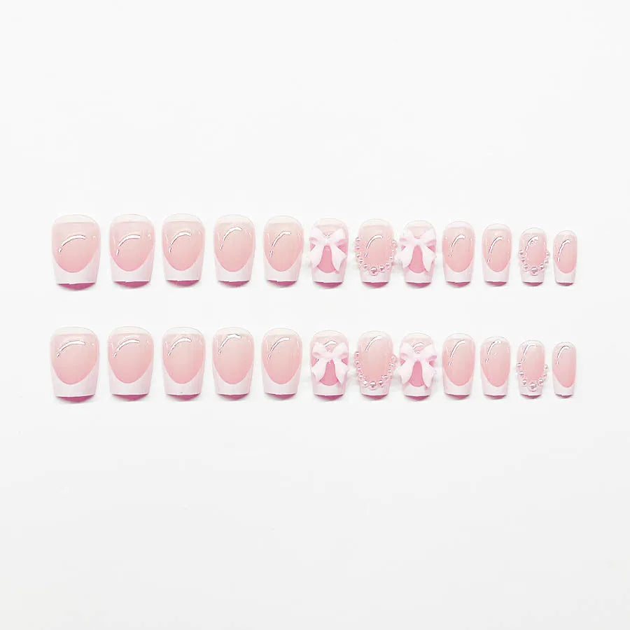 Short white French style press-on nails with bow, tulip, and leopard print designs.