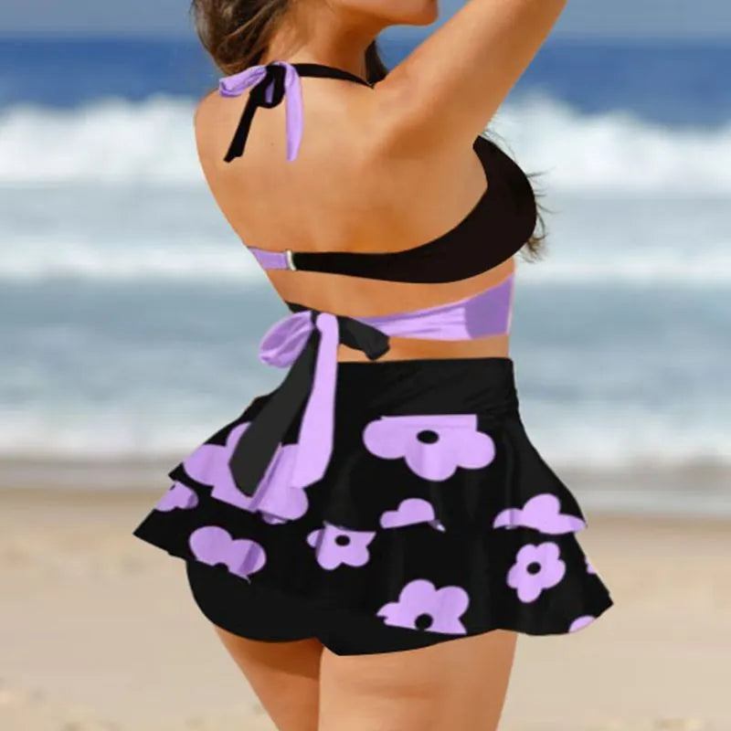 Purple and black women's bikini swimsuit set with lace-up details and a matching skirt.