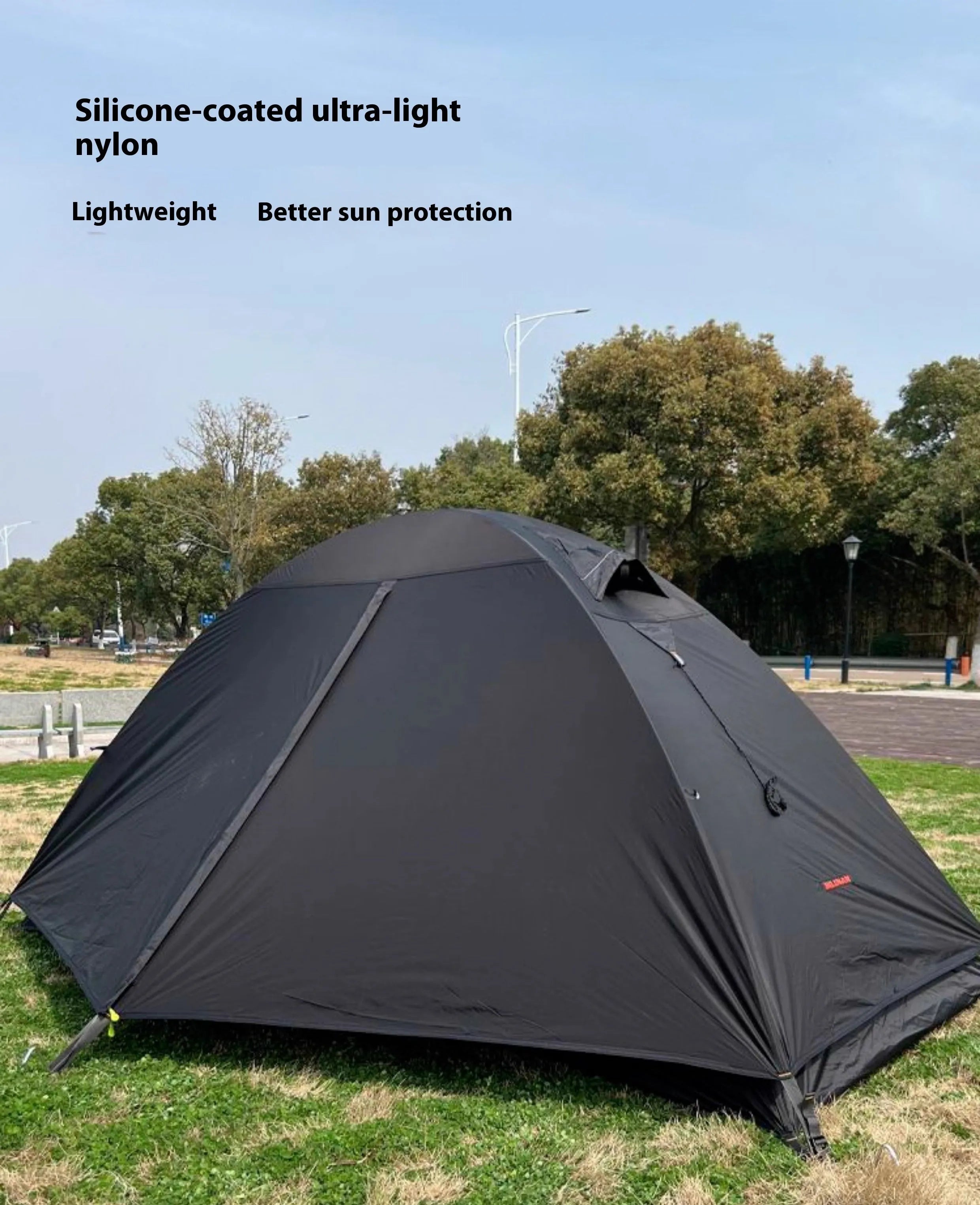 Black single person double account tent with aluminium poles pitched outdoors.