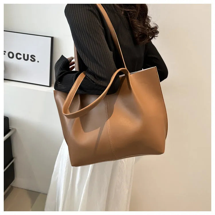 PU leather messenger bag in bucket shape with stitching detail, black colour, double shoulder straps, open pocket outer