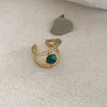 Geometric open ring made of titanium steel with a green natural stone.