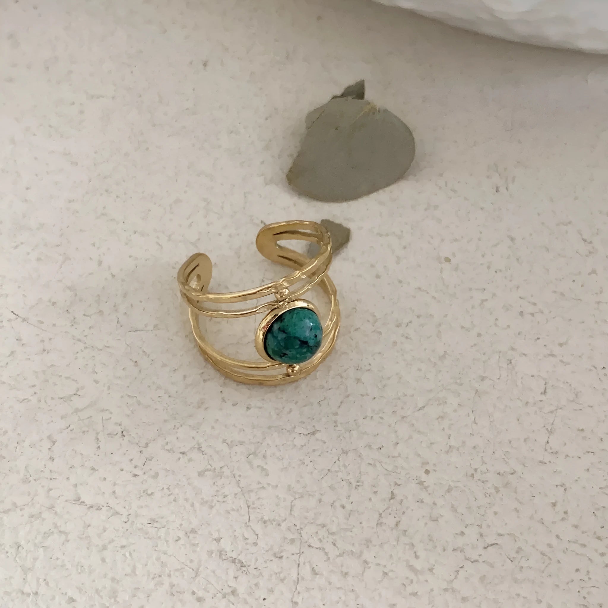 Geometric open ring made of titanium steel with a green natural stone.