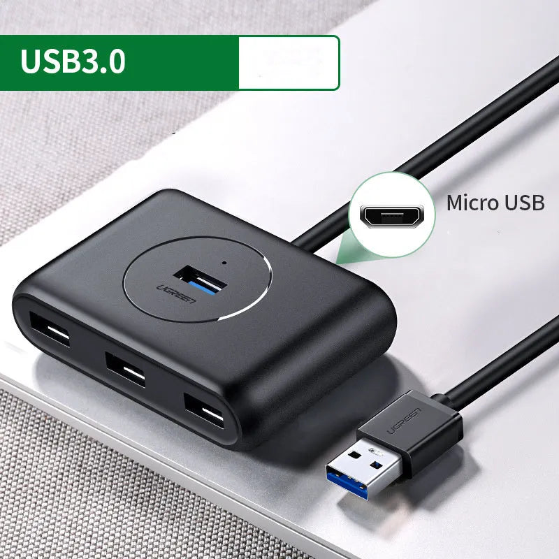 Deep black USB splitter hub with four ports, ABS plastic shell, and indicator light on desk