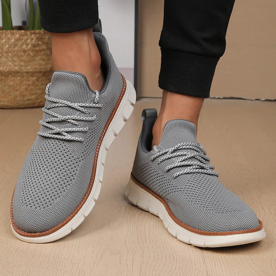 Men's grey and black low-heel casual sneakers with woven mesh fabric uppers and round toe.