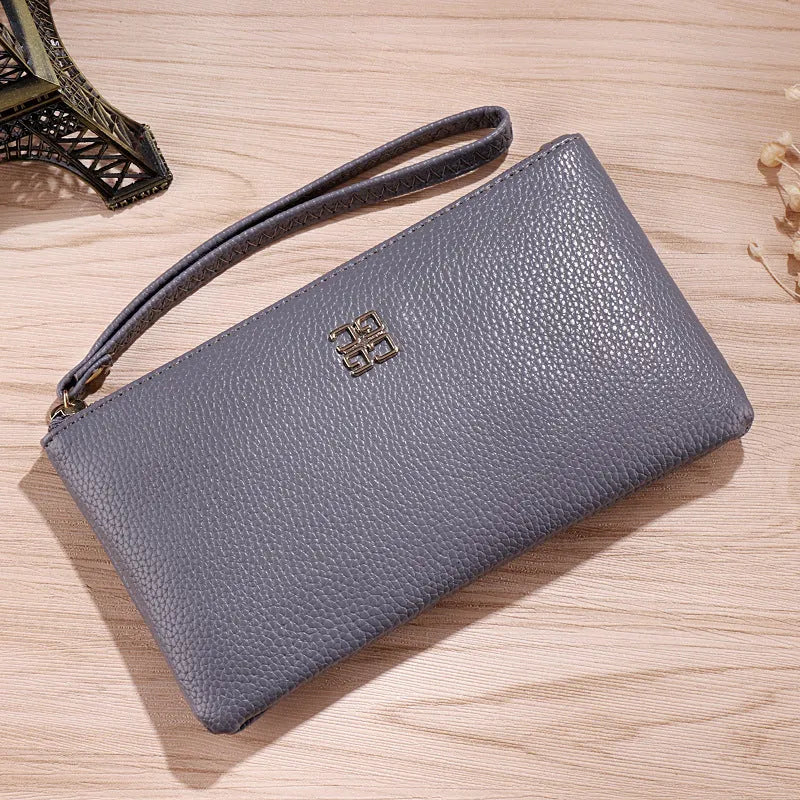 Long 55-inch PU leather zip wallet handbag in a solid colour with sewing line detail.