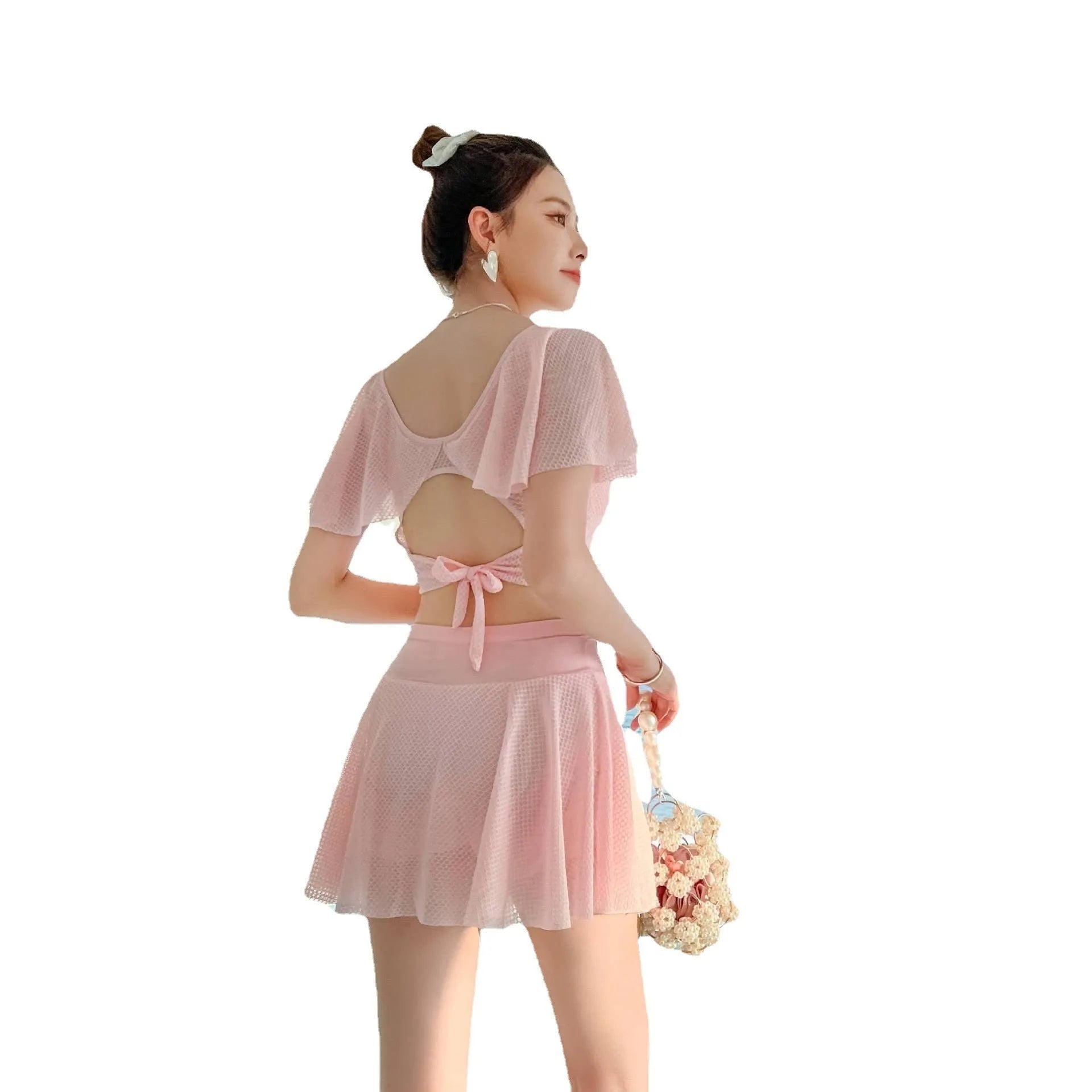 White two-piece women's swimsuit with a skirt bottom, shown alongside black and pink colour options.
