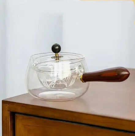 Transparent rotating glass teapot with wooden handle and integrated tea infuser