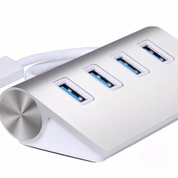 Silver aluminium alloy four-port USB 3.0 hub on a desk with cables connected, 98x58x30mm