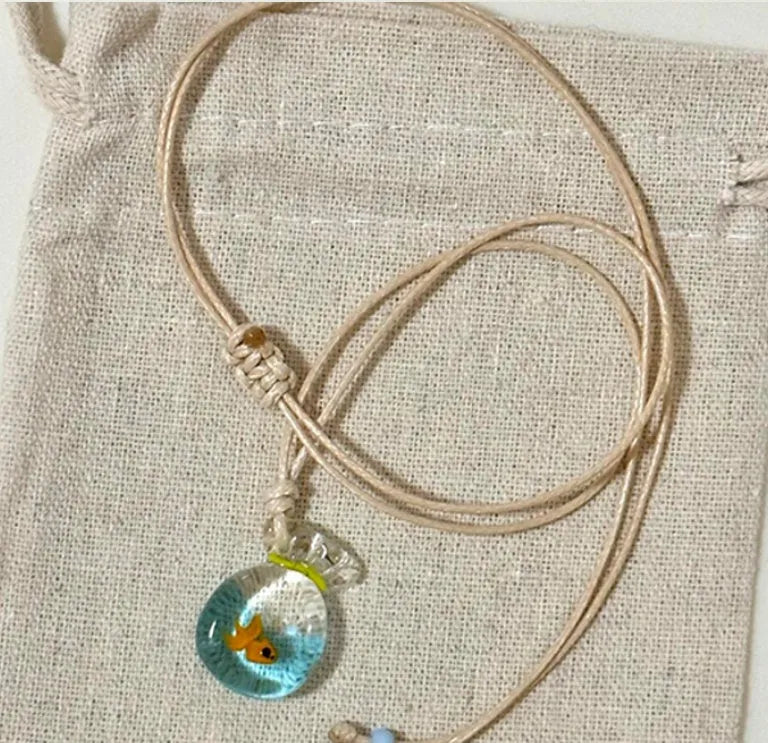 Women's joker pendant necklace with coloured glaze charm on a cotton and linen clavicle chain.