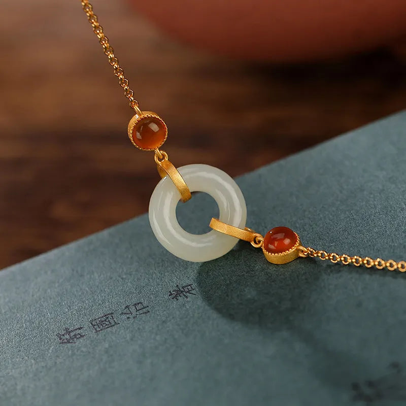 Gold-coloured women's bracelet with a silver and jade peace buckle on an adjustable chain.
