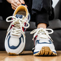 Men's yellow, black, and white mesh and synthetic leather casual sneakers with round toe and lace-up front.