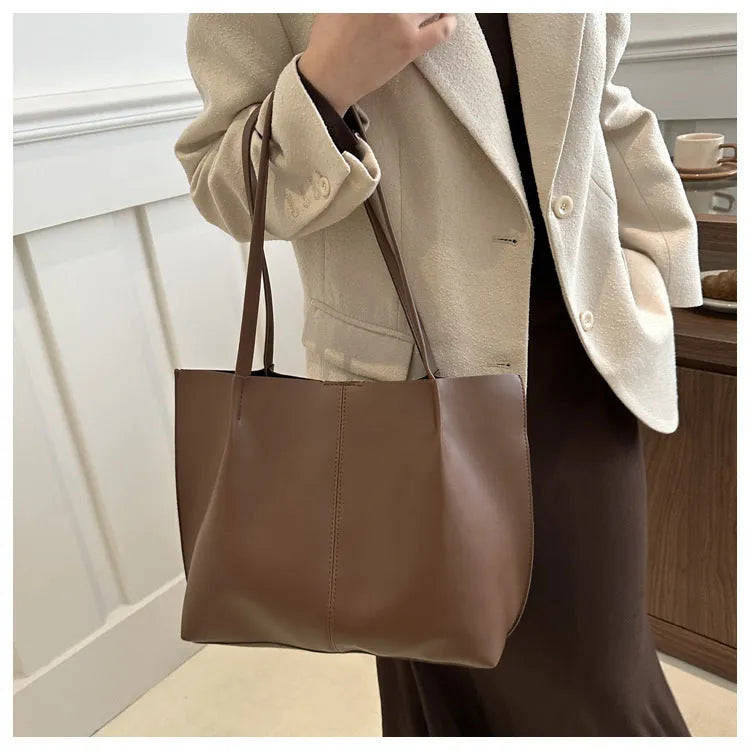 PU leather messenger bag in bucket shape with stitching detail, black colour, double shoulder straps, open pocket outer