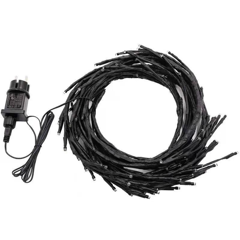 Flexible plastic LED vine garland with warm white lights shaped on a wall.