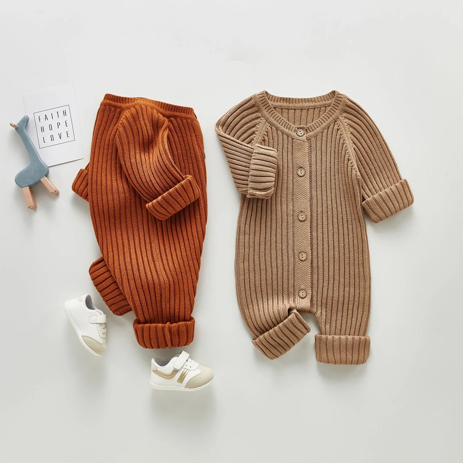 Baby long-sleeved knitted jumpsuit romper pullover in beige, size 80cm, lying flat on a white background