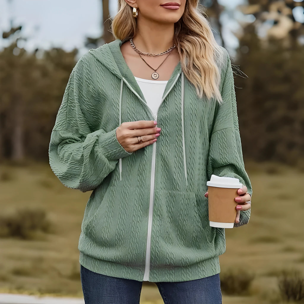Green women's loose-fit zip-up hooded sweater coat on a hanger.