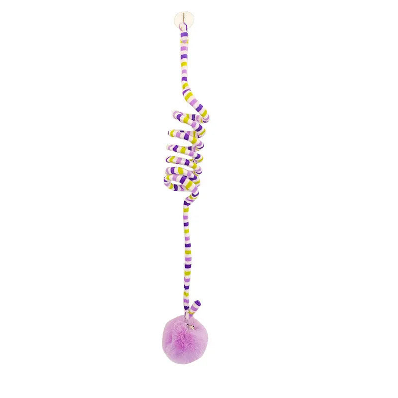 Spring-mounted inflatable ball cat toy with bell, attached to a door via a clear suction cup.