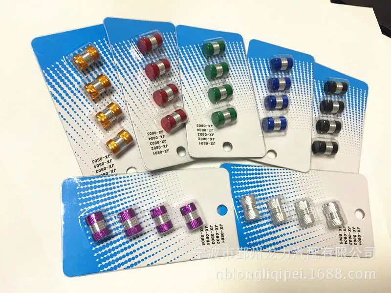 Seven aluminium alloy tyre valve dust caps in black, blue, gold, green, purple, red, and silver on a white background.