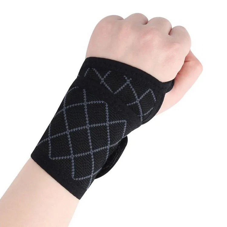 Black adjustable wrist brace for carpal tunnel support with hook-and-loop strap on hand