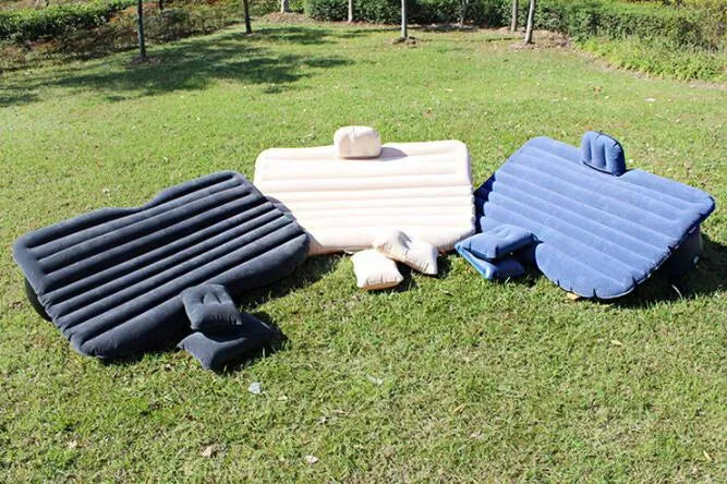 Black inflatable car bed with flocked material laid out in a five-seater vehicle boot.
