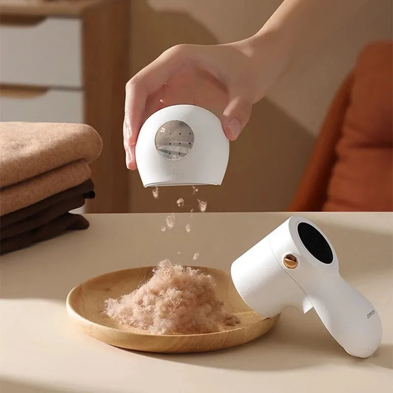 White USB rechargeable electric lint remover and fabric shaver with LED display on a grey background.