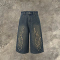 Men's black cropped denim shorts with orange flame embroidery patch on leg