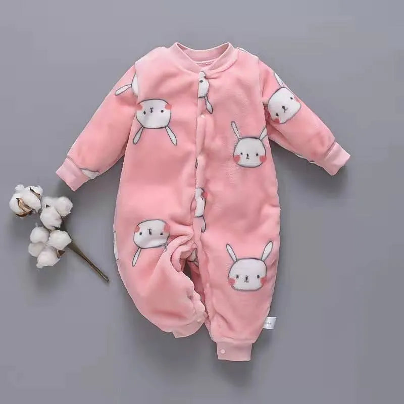 Baby wearing a long-sleeved flannel romper in a pink bunny head print, showcasing the 100% cotton fabric.