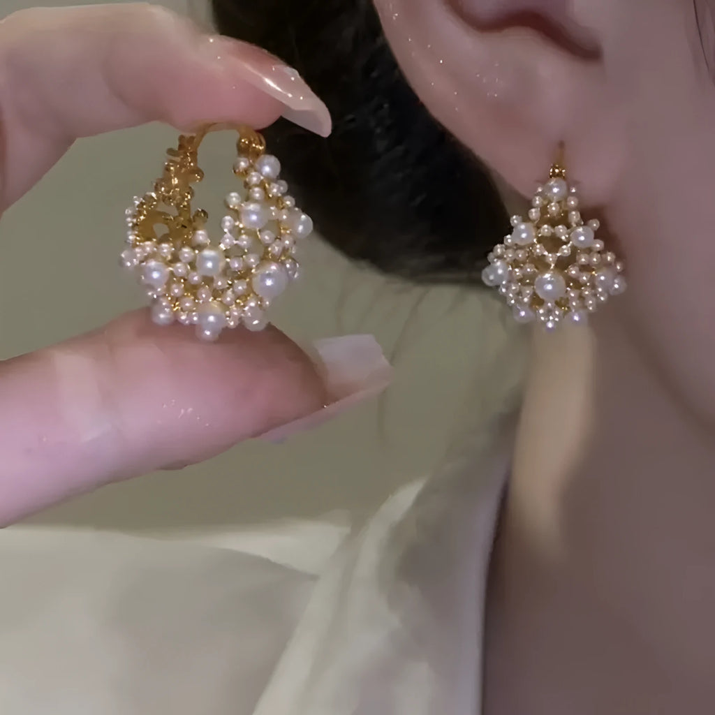 Gold-coloured copper flower basket earrings with small rice-shaped beads and pearl inlay detailing.