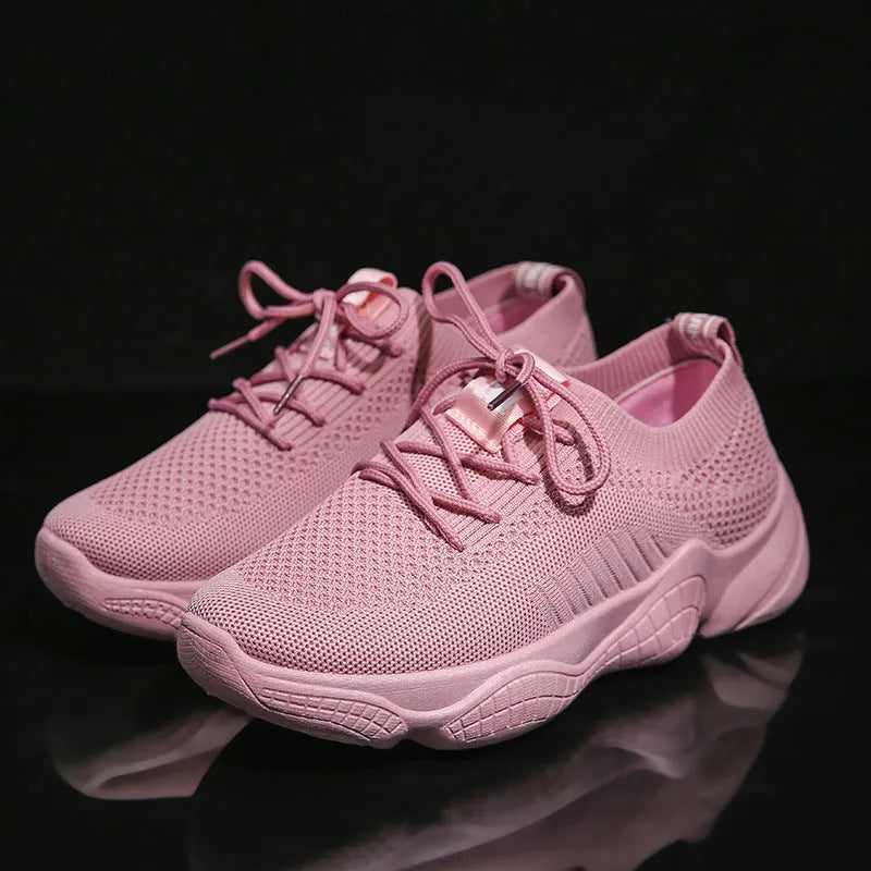 White thick-soled women's flyknit trainers with front strap and rubber sole.