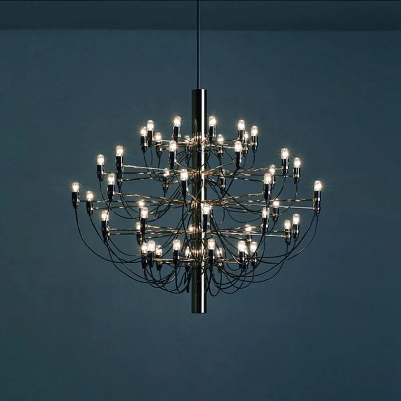 Modern three fork wooden floor lamp with an acrylic shade in a living room setting.