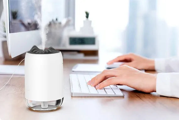 Mini cylindrical USB humidifier in turquoise green with night light on wooden desk