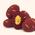 Red sweet potato-shaped dog puzzle toy with peel-open design revealing hidden treat compartments