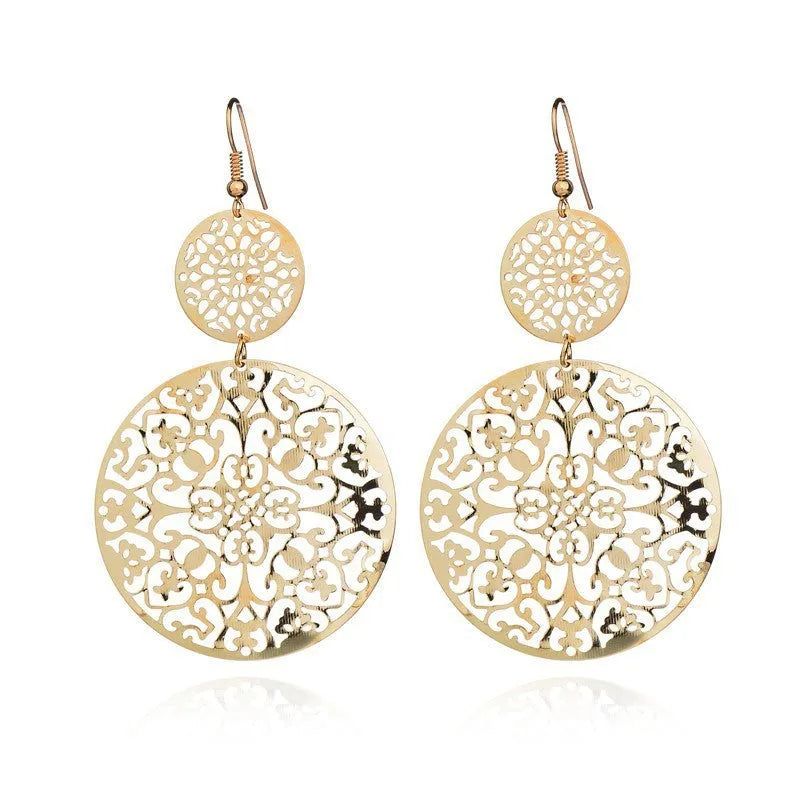Women's round hollow gold drop earrings with dangle design on a light background
