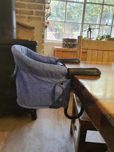 Portable baby dining seat with safety belt in blue, grey or red colours folded to show compact 42x36x7cm size