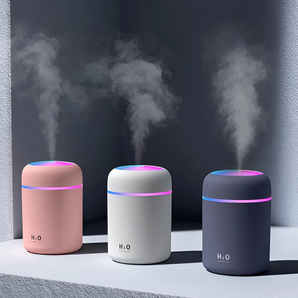 Pink, white, or navy blue USB mini humidifier with colourful lights on a desk