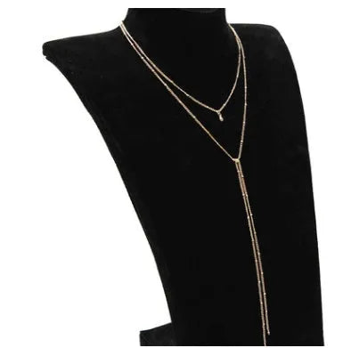 Multilayer lariat necklace in gold alloy plating with two layered strands and extension chain on white background